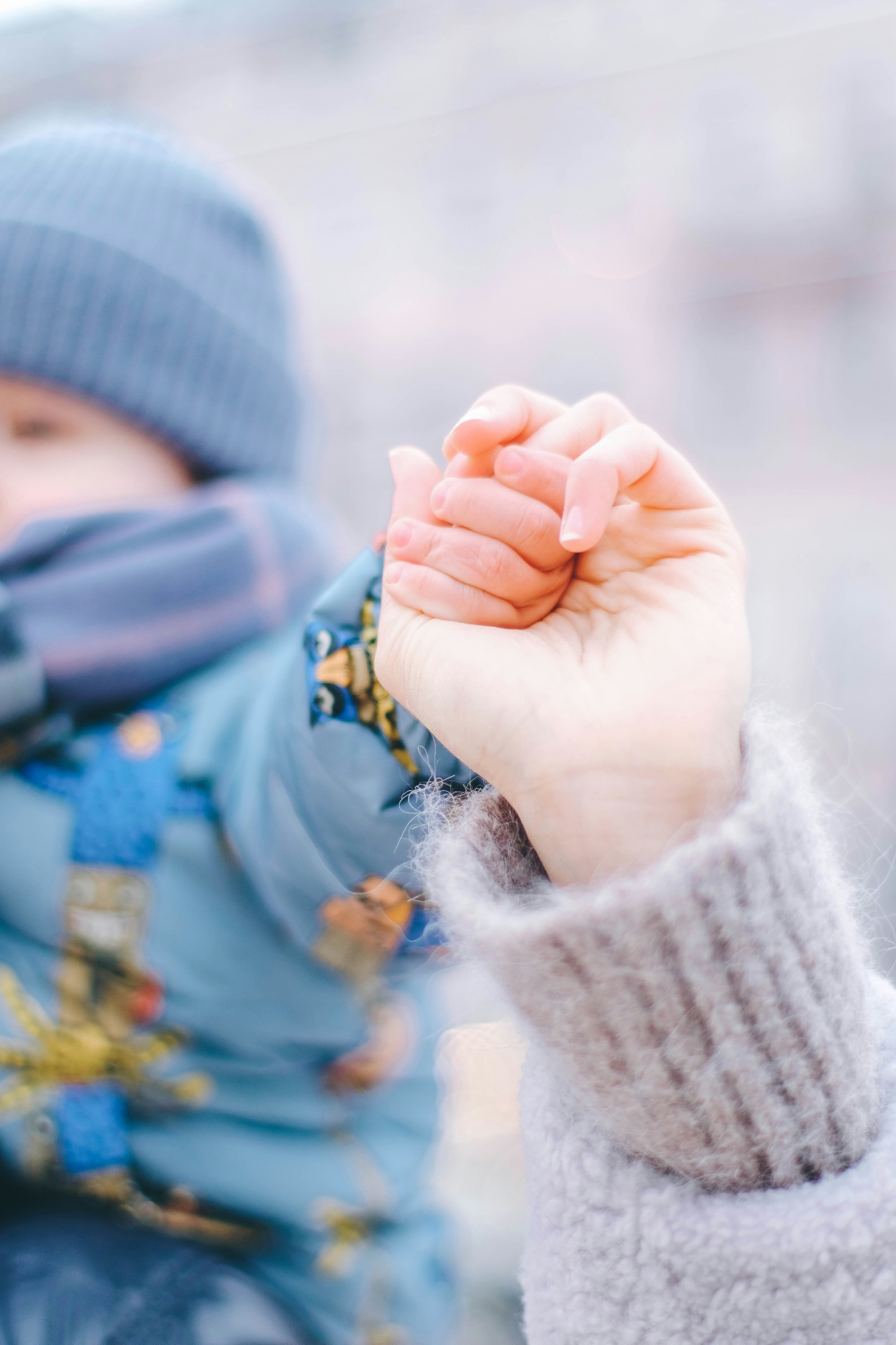 A child holding a caregiver's hand